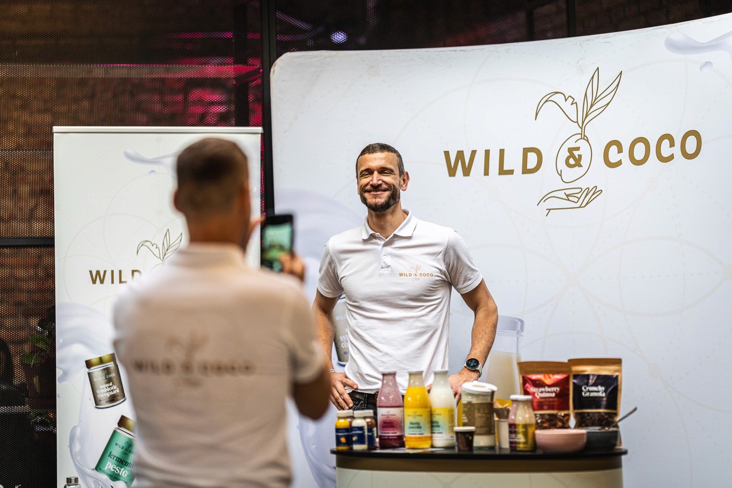 Brand representative presenting products at a sponsor booth during a business conference.