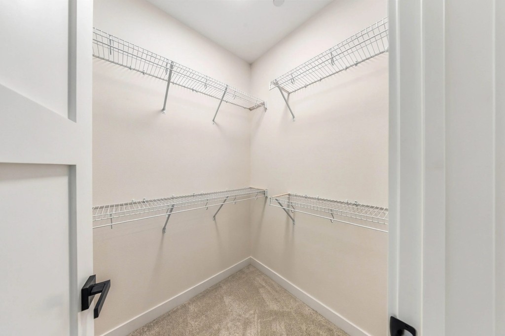 Primary walk-in closet with wire shelving on three walls