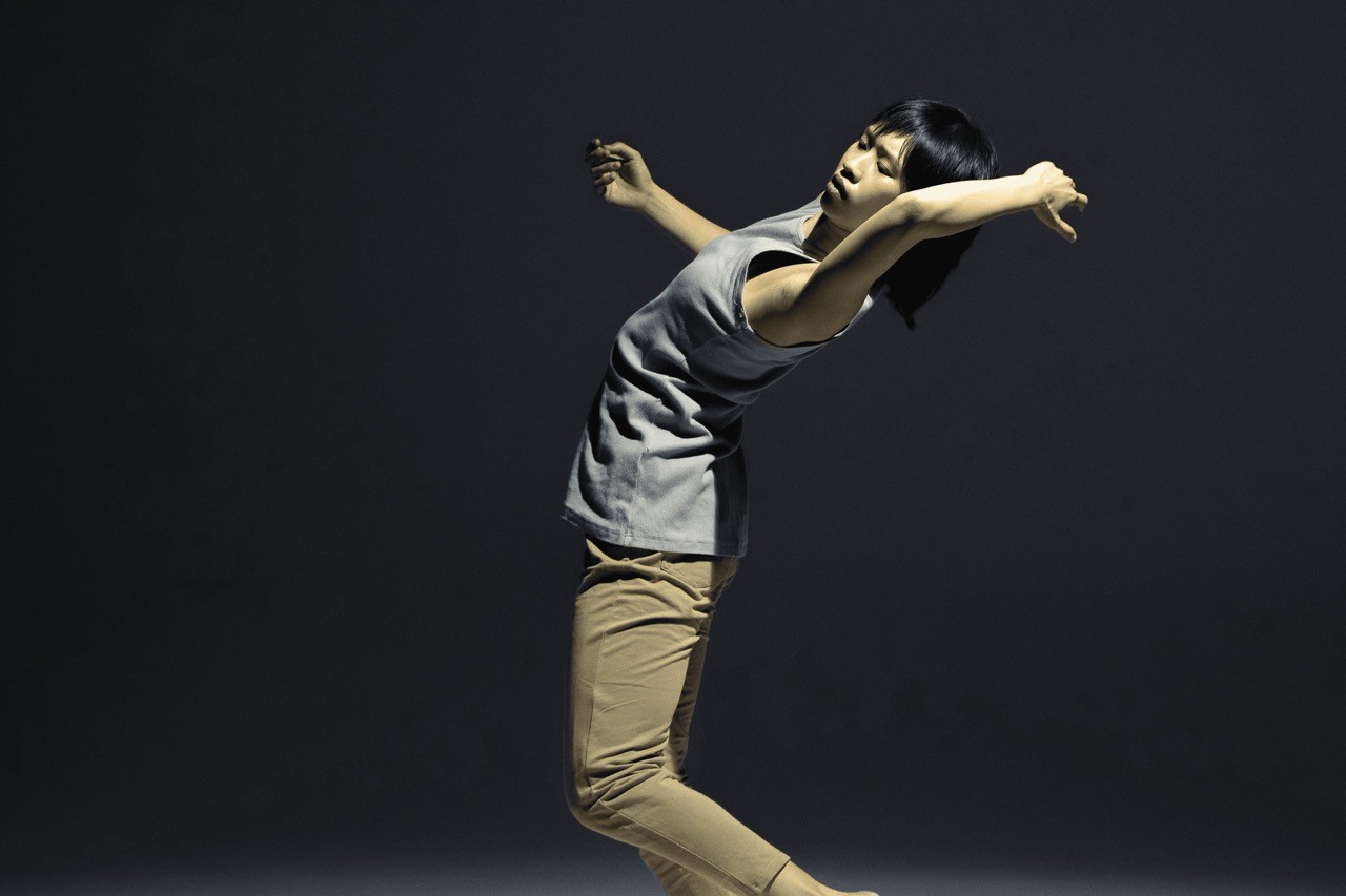 a woman is jumping in the air with her arms outstretched