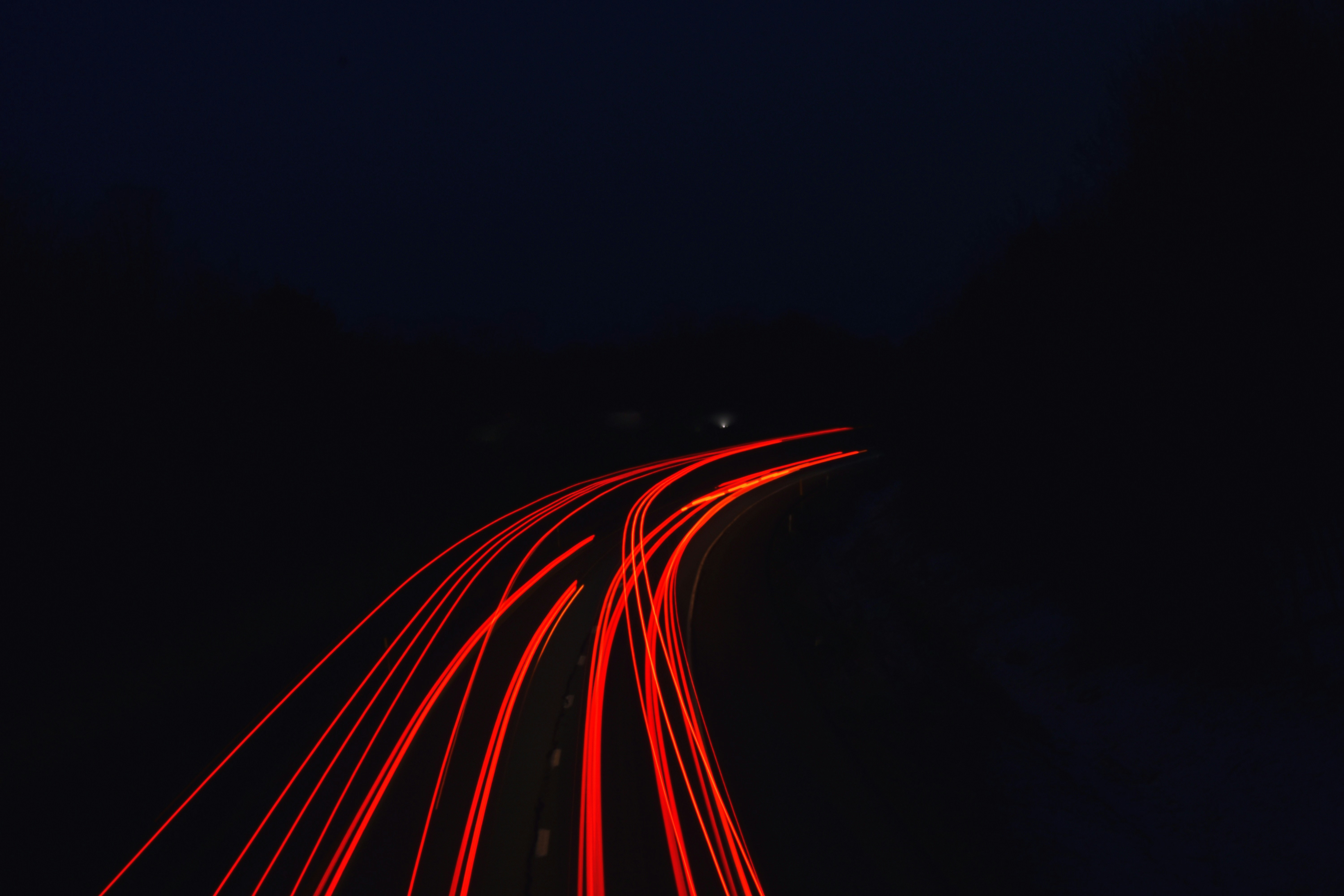a long exposure photo of a highway at night
