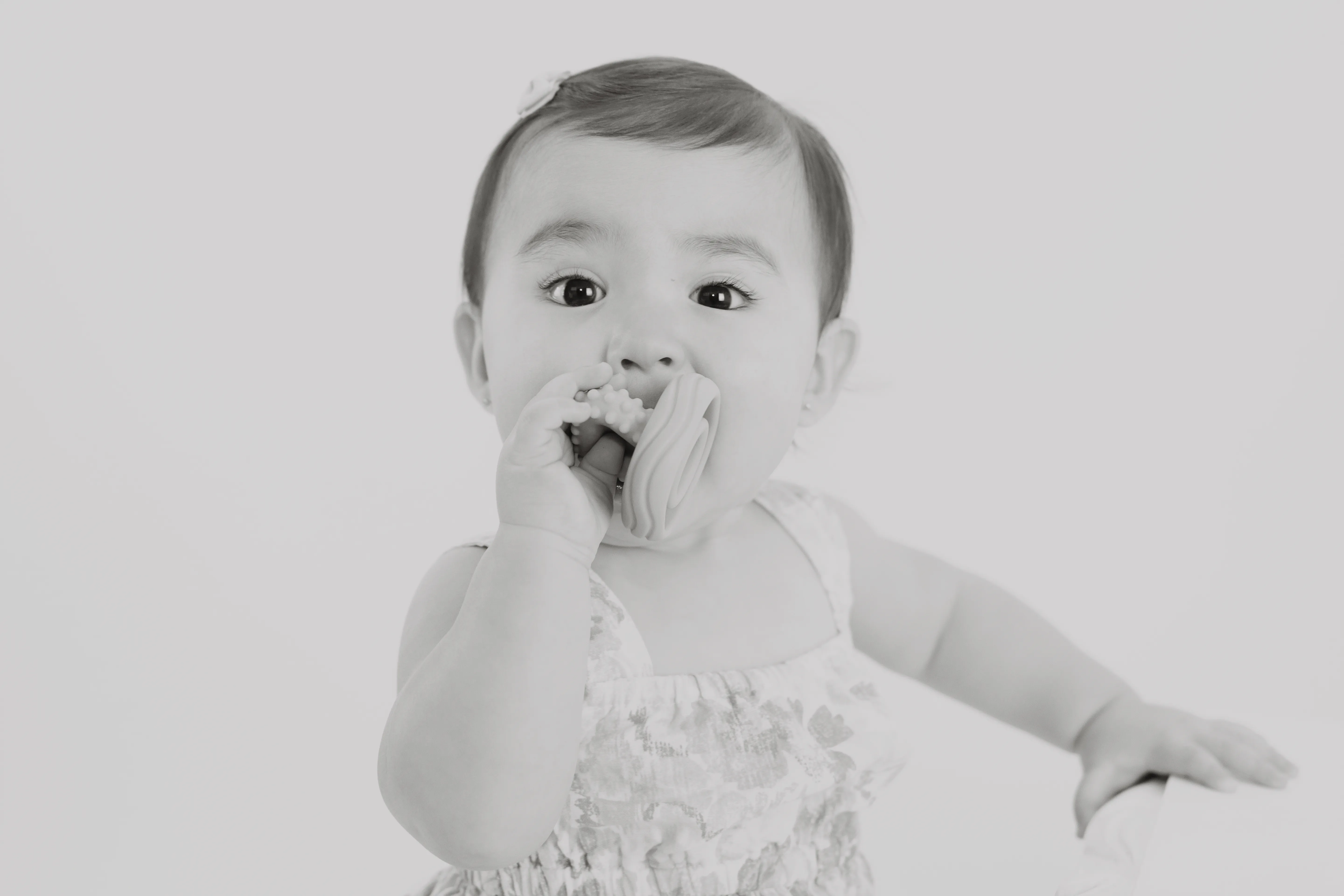 Retrato en blanco y negro de bebé llevándose su dedo a la boca