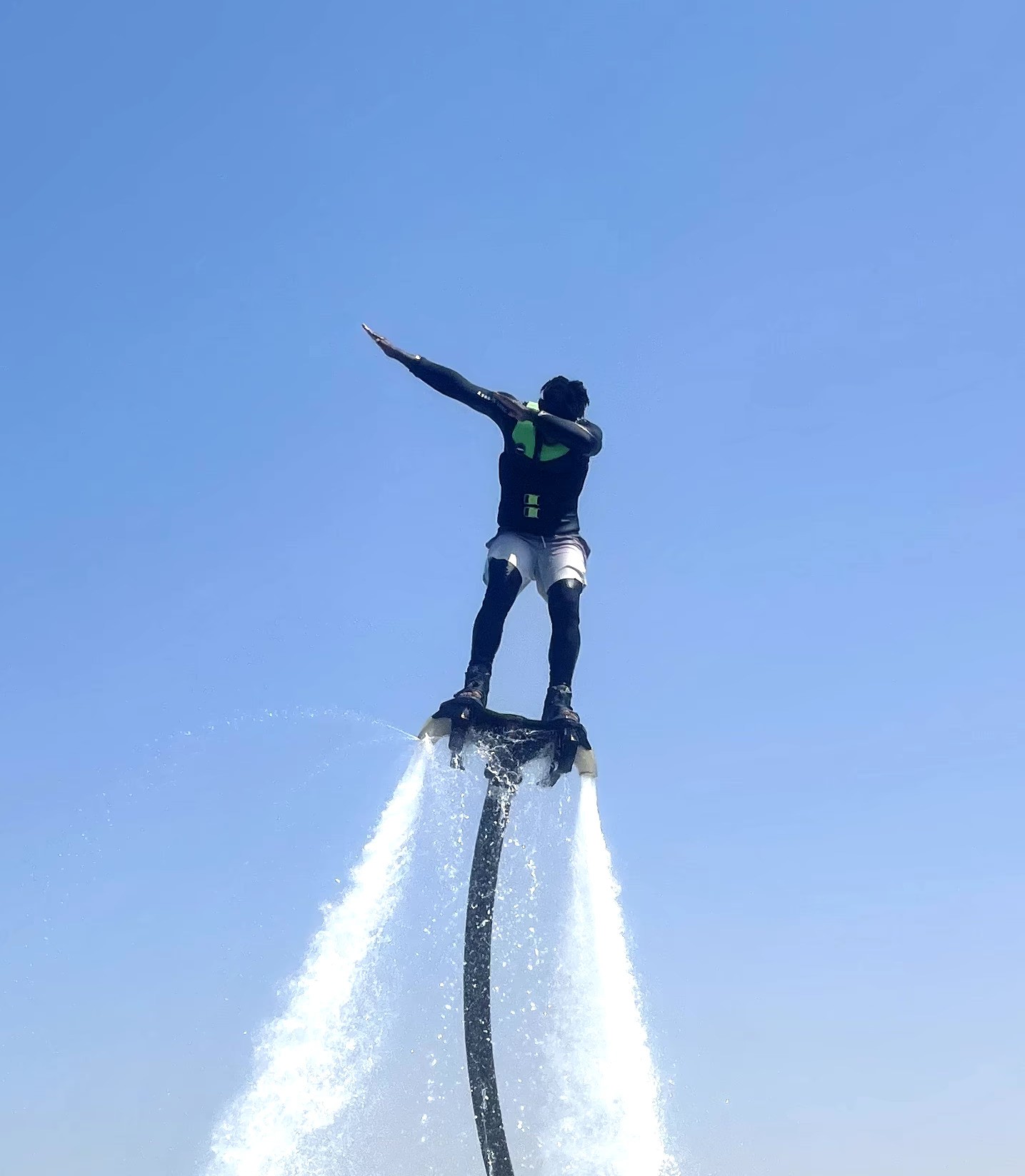 Man enjoying flyboarding, showcasing thrilling family activities in Dubai over calm waters.