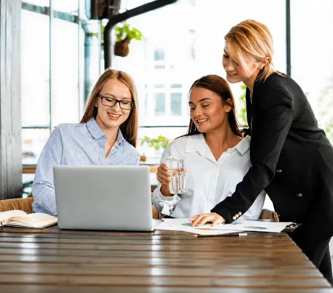 Business professionals reviewing digital payment information on a laptop during a meeting.