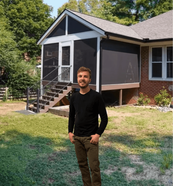 Modern living room with abstract art, beige sectional sofa, indoor plants, and large windows.