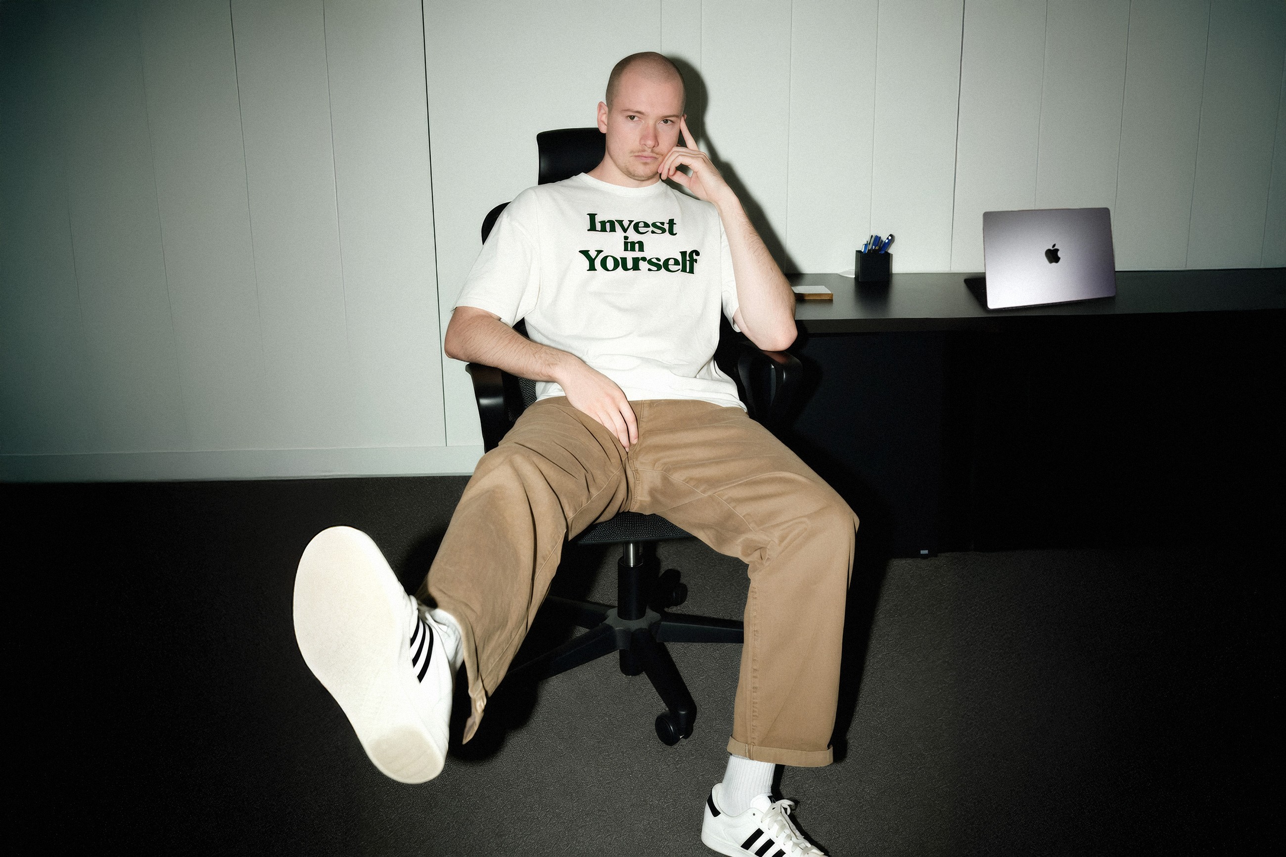 Niklas Hellger (der Gründer von NO ONE STUDIO) auf einem gelben Stuhl in Fotoshooting Kulisse.