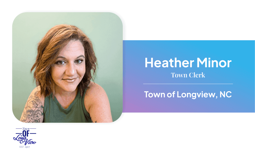 Female municipal clerk seated at office desk with nameplate reading 'Heather Minor, City of Longview,' with office décor visible in the background.
