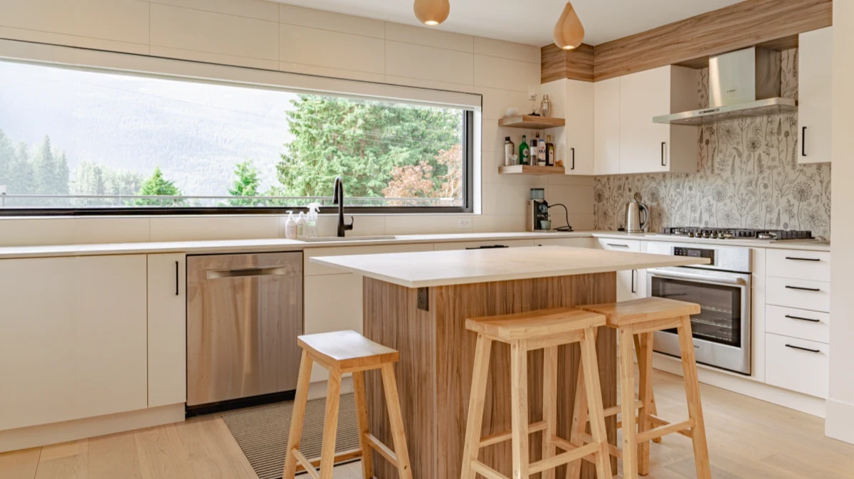 Custom kitchen featuring waterfall edge island, natural wood cabinetry, white countertops, and designer pendant lighting built by Vancouver Custom Homes