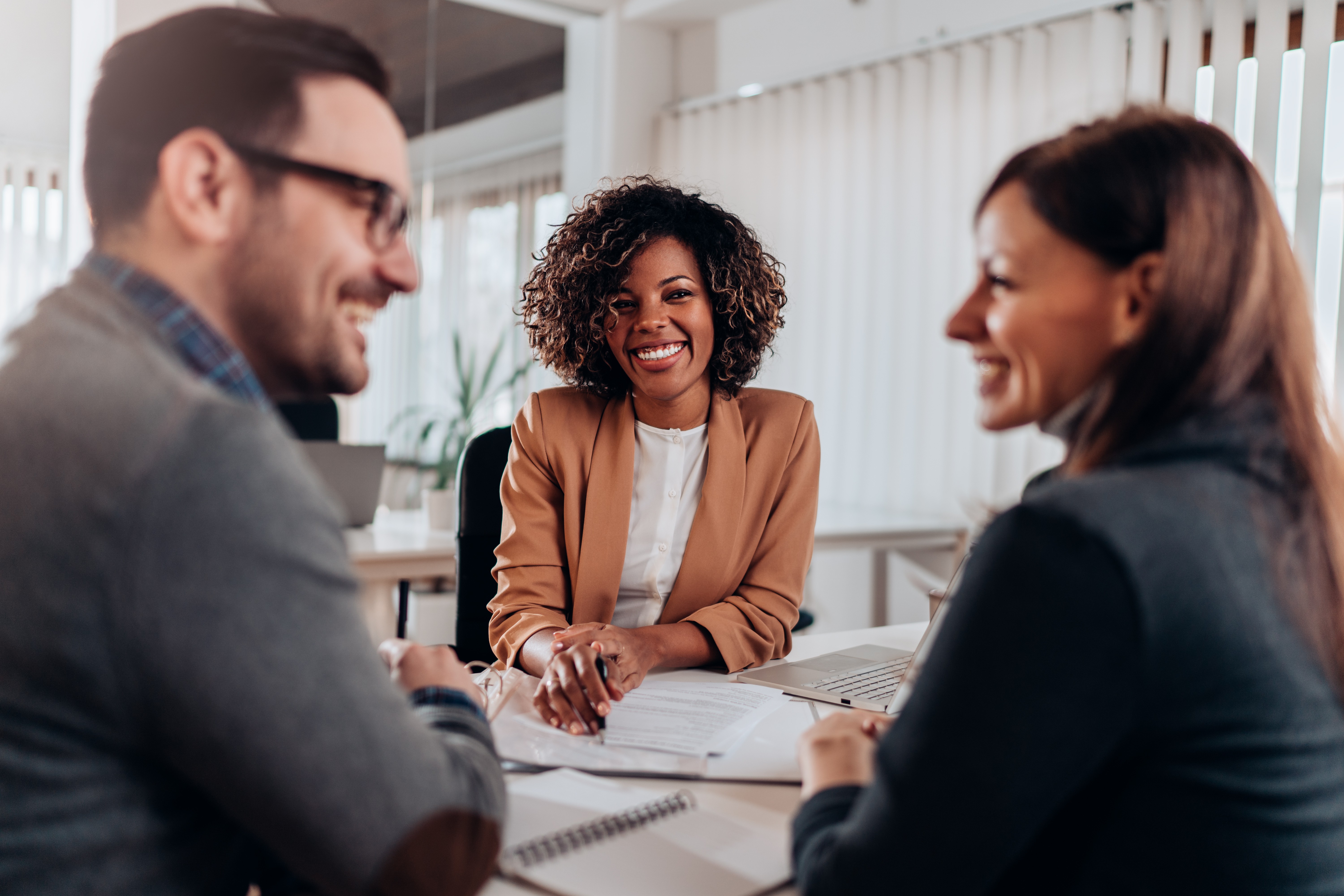 financial services expert meeting with two clients to explain portfolio changes