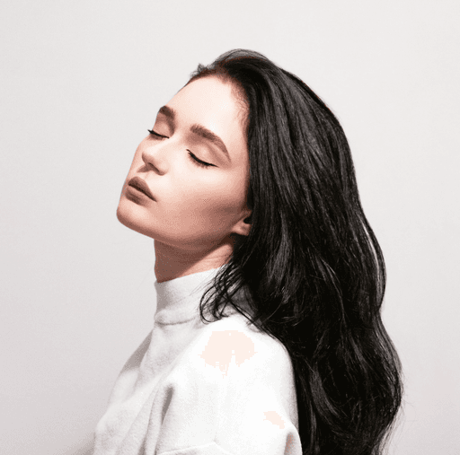 a woman with long black hair standing in front of a wall
