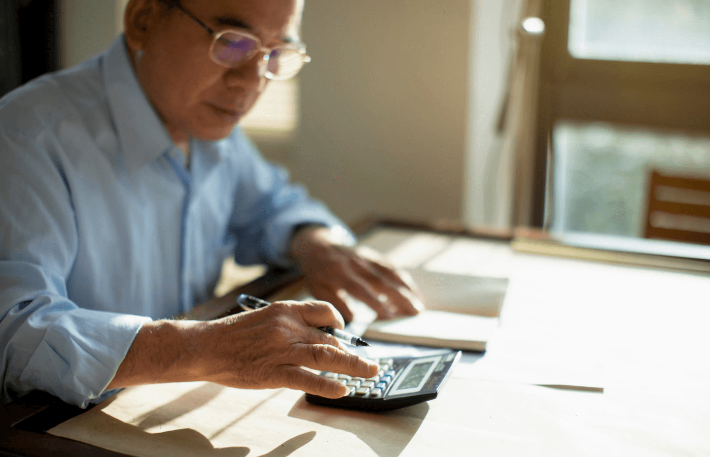 a man using a calculator while sitting at a table