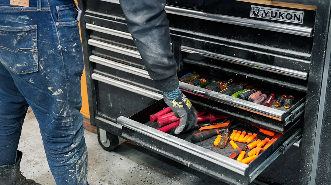 Technician accessing tools in a workshop environment for electric vehicle repair.