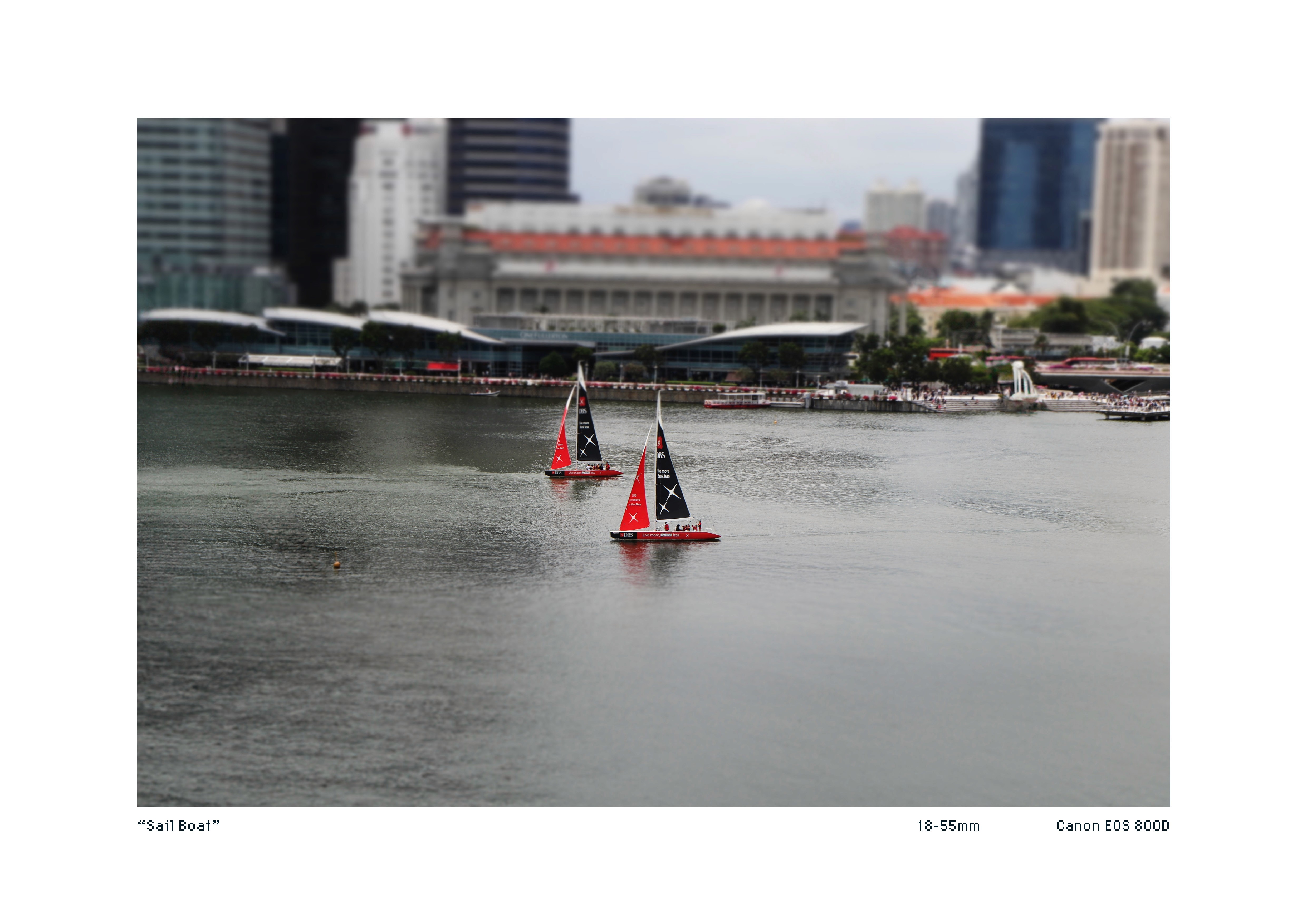 Tiltshift image of Two boats with DBS Bank flags at Marina Bay
