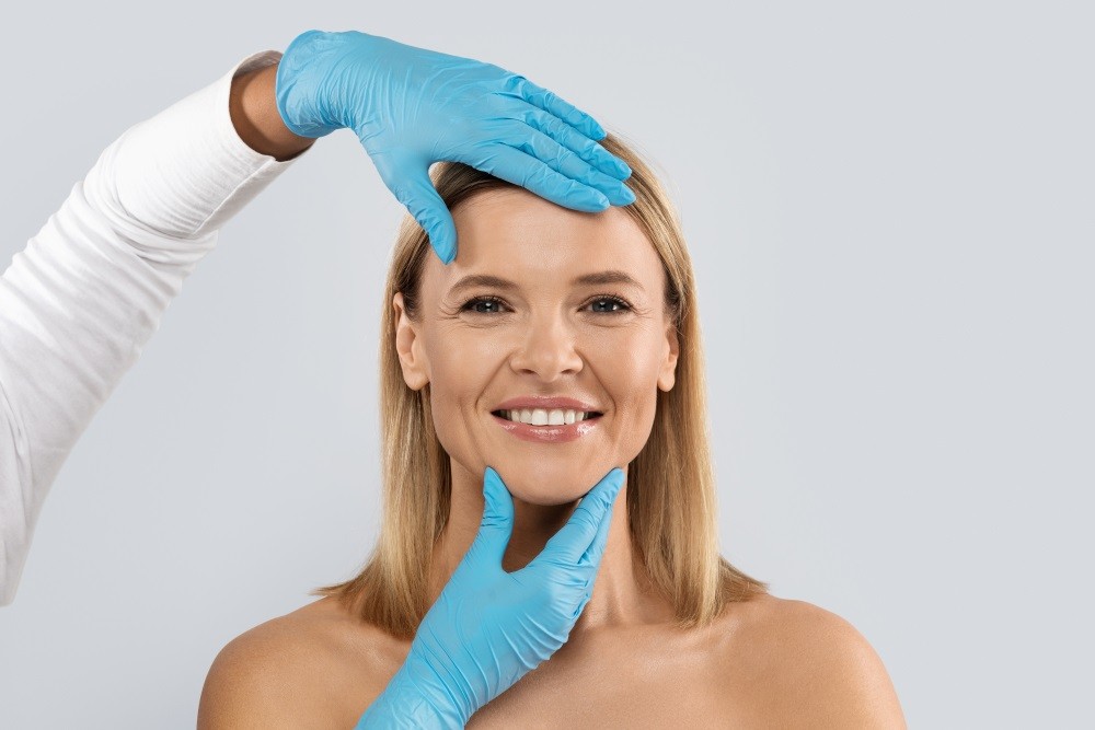 Doctor performing facelift on smiling patient