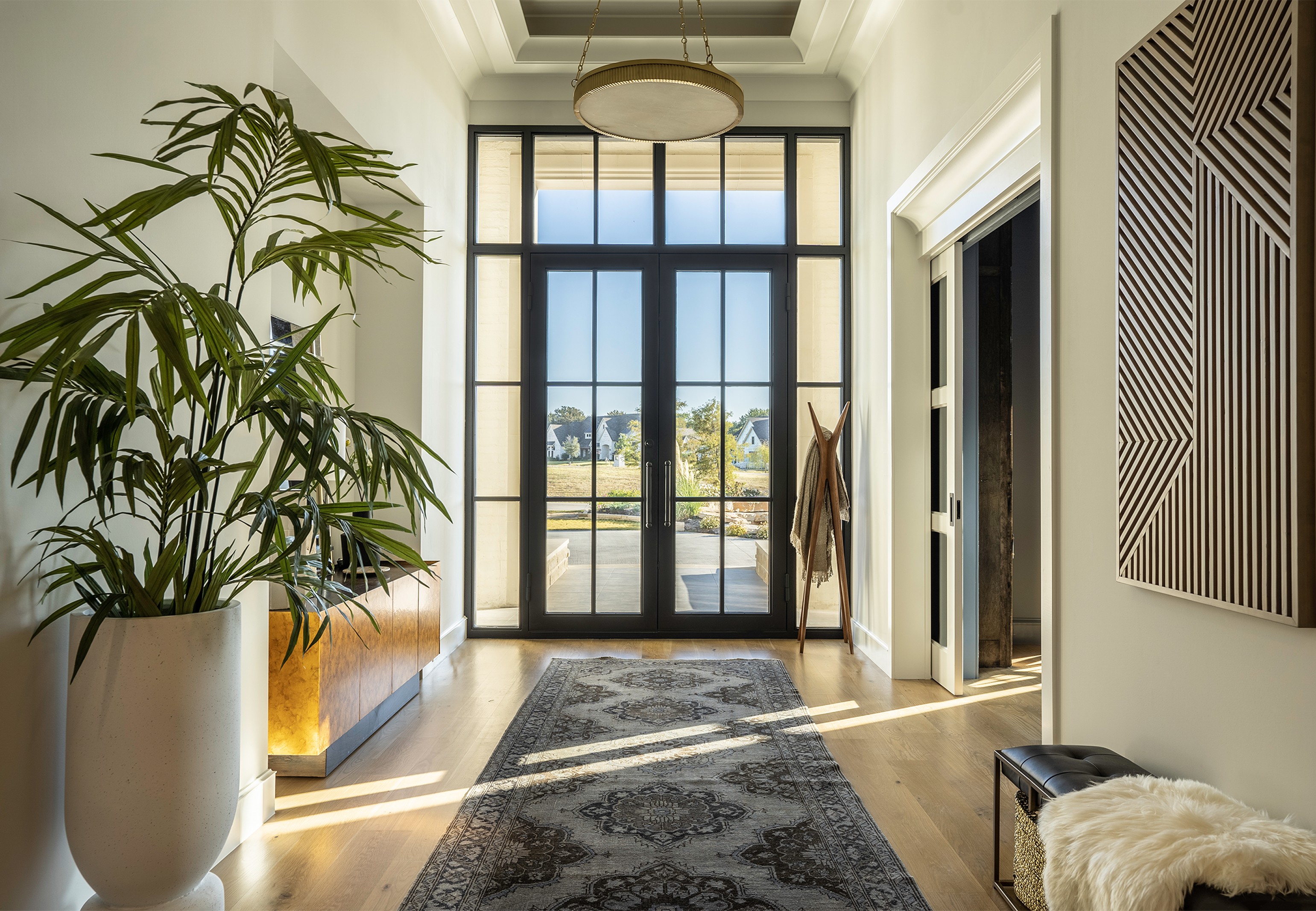 Luxurious primary bathroom with copper freestanding tub, crystal chandelier, and hexagonal tile backsplash