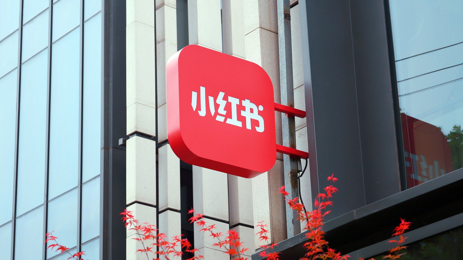 A red circular sign with a white left arrow, indicating a left turn, next to a green street name sign.