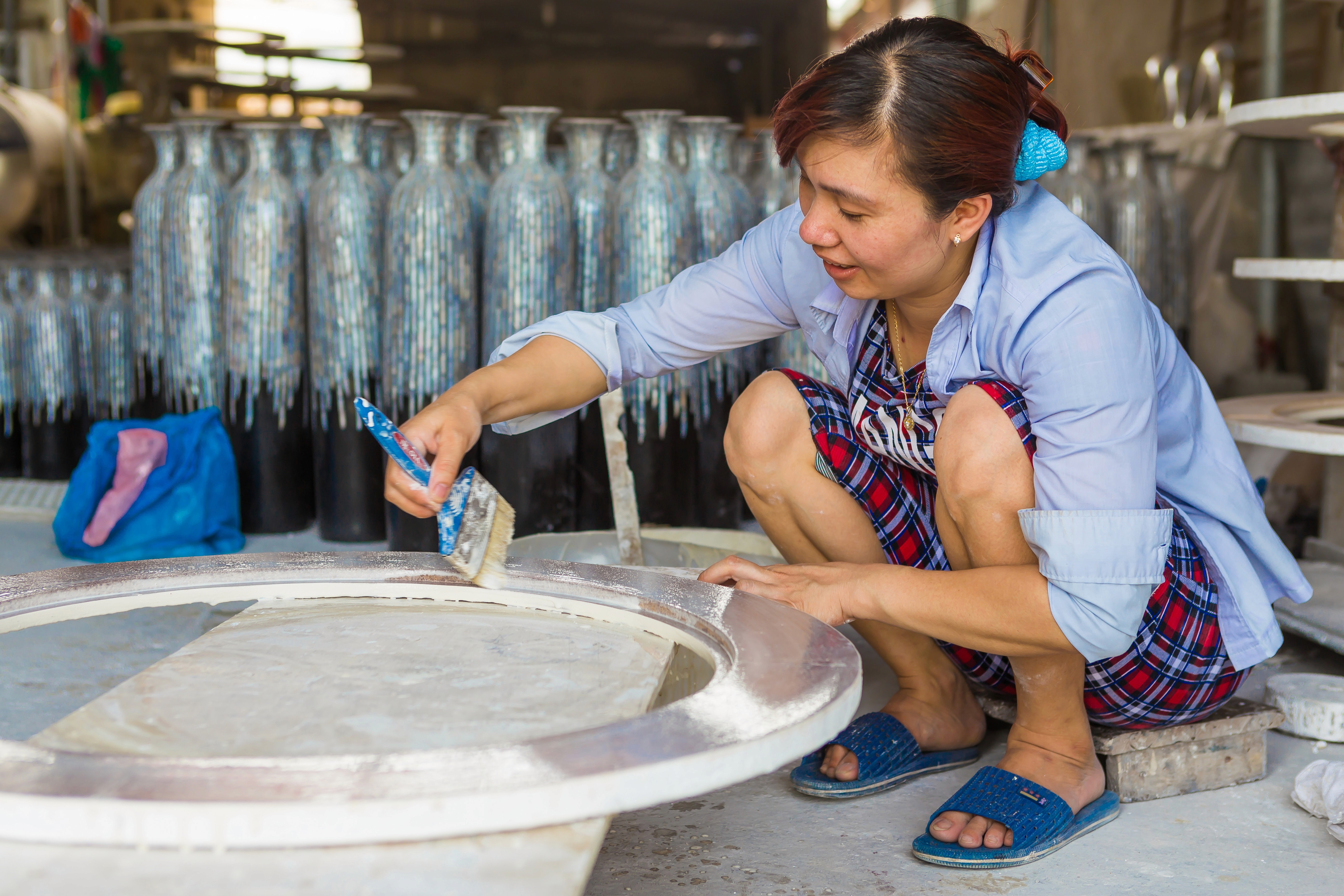 Vietnamese factory worker making a mirror