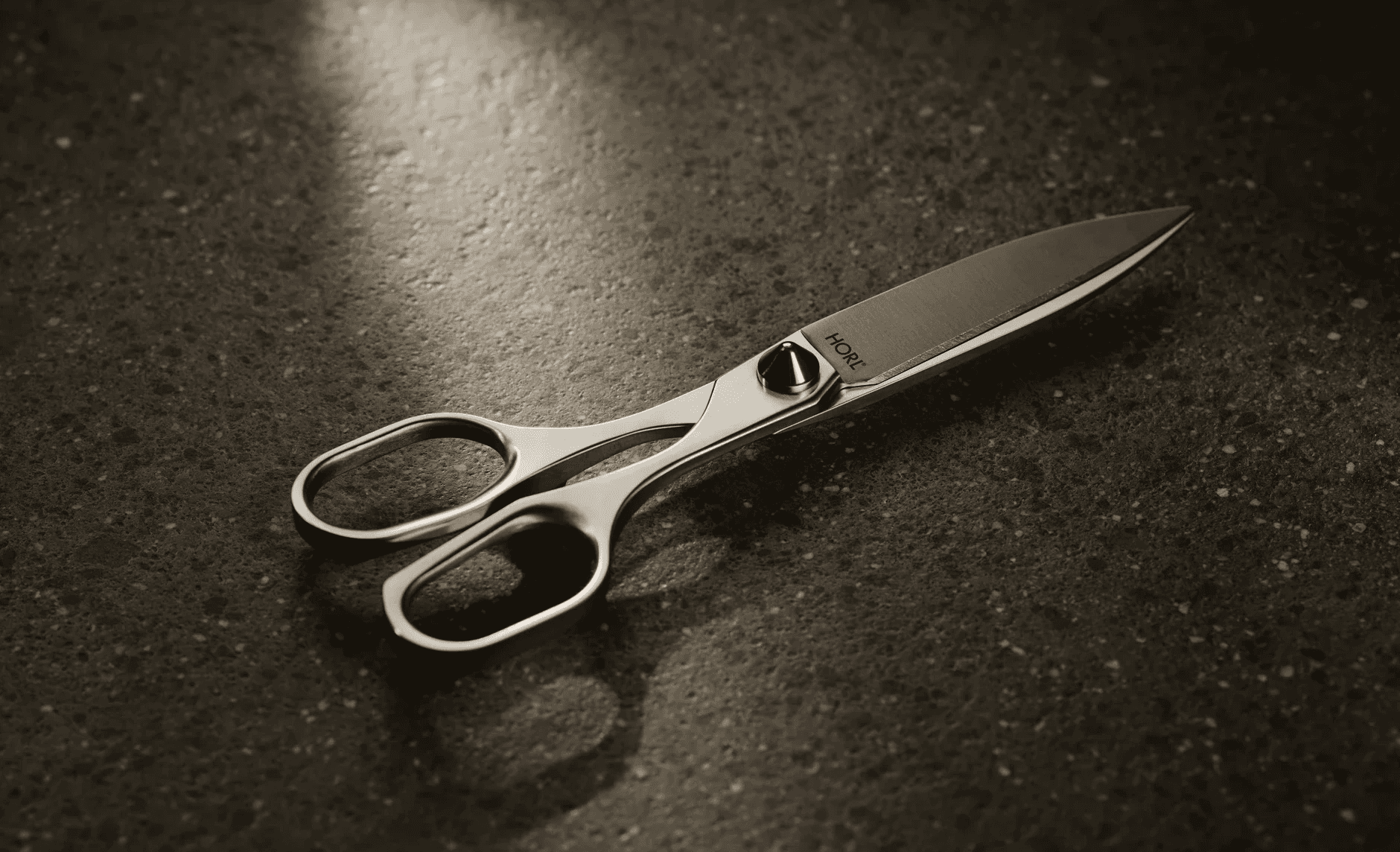 Die hochwertige, nachschleifbare HORL Schere auf einem dunklen Hintergrund.