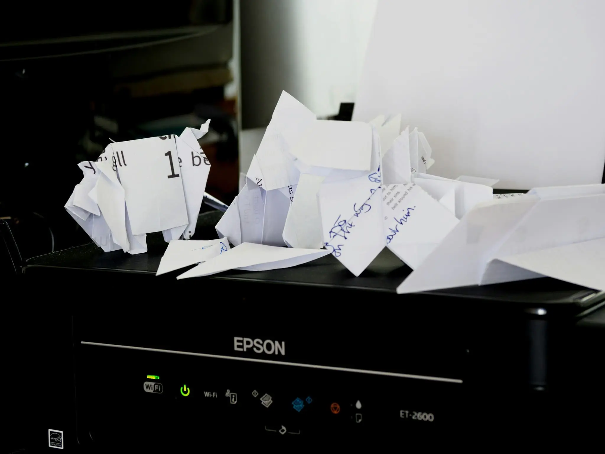 Printer with crumpled draft pages symbolizing common cease and desist letter drafting mistakes