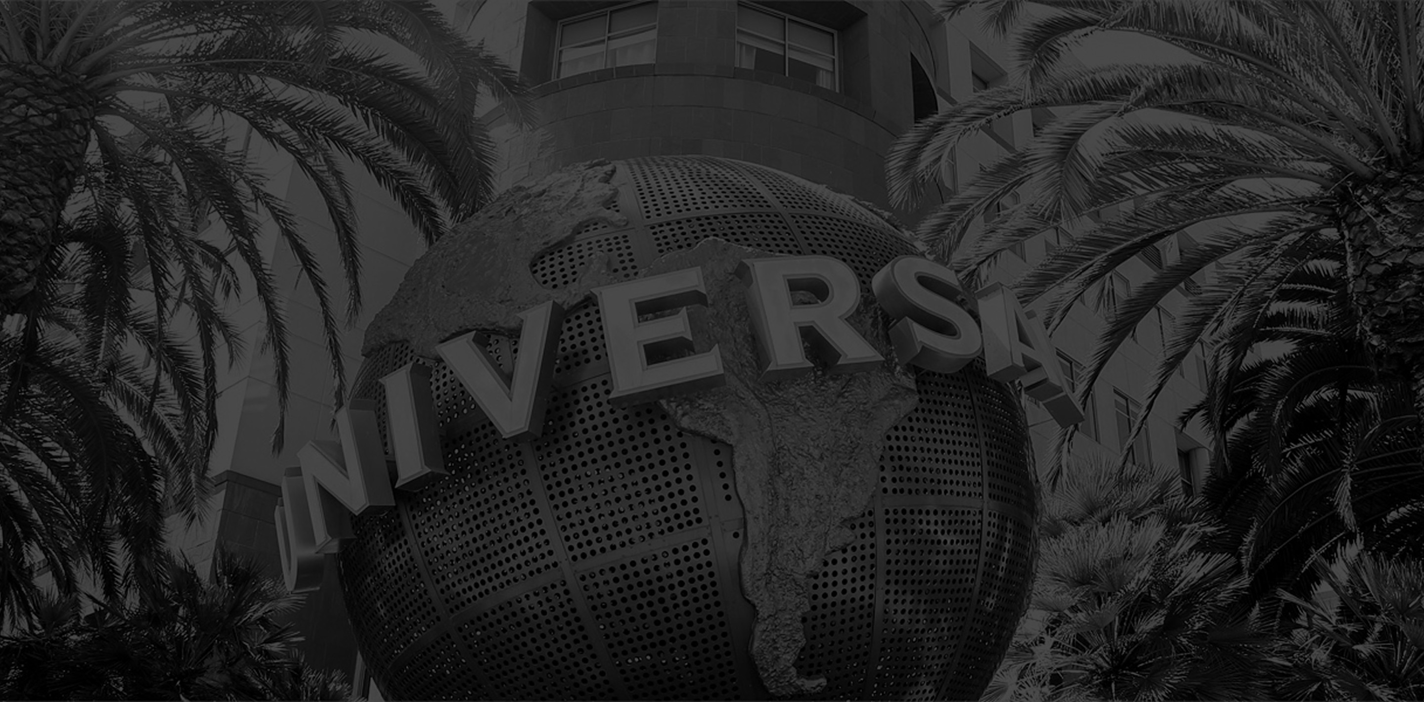 Black and white background image of the Universal glob statue nessled amidst tropical flora