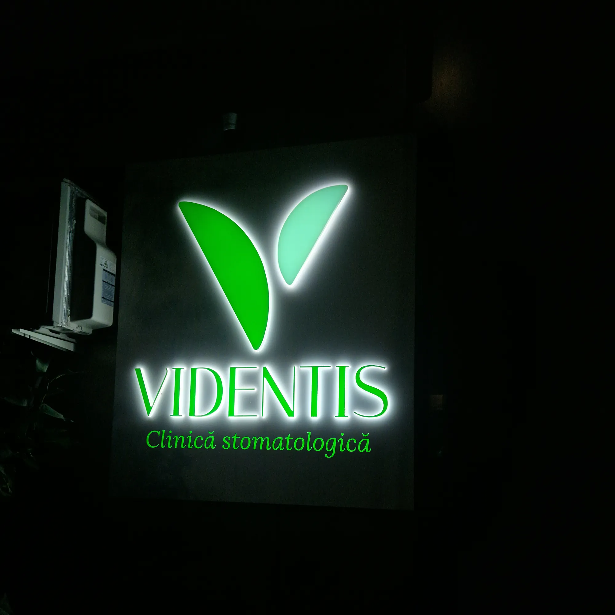 Casetă luminoasă Videntis din alucobond cu litere din PMMA alb iluminate, seara