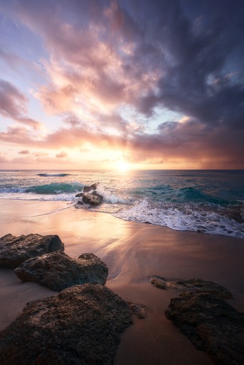 A lighthouse on a beach on a cloudy day