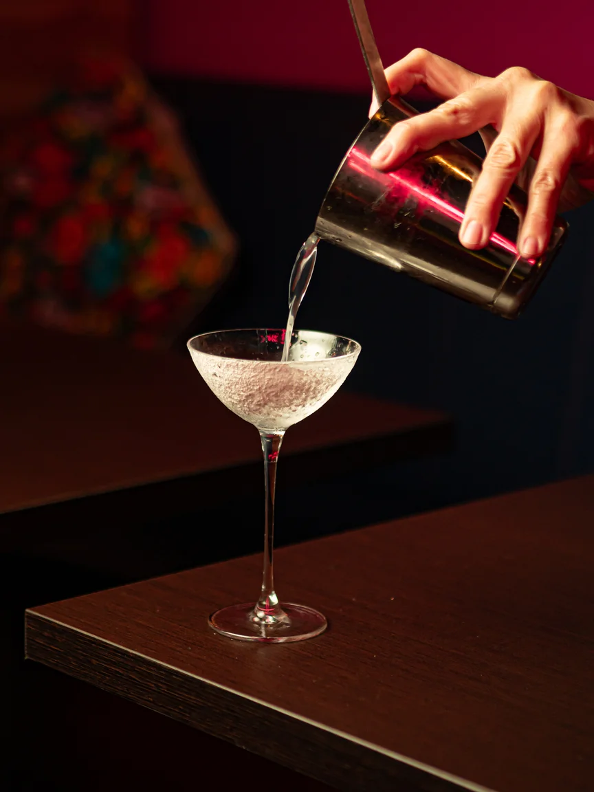 Bartender sirviendo una margarita clasica con borde de sal y lima en la coctelería mexicana Piñata Cantina Barcelona.