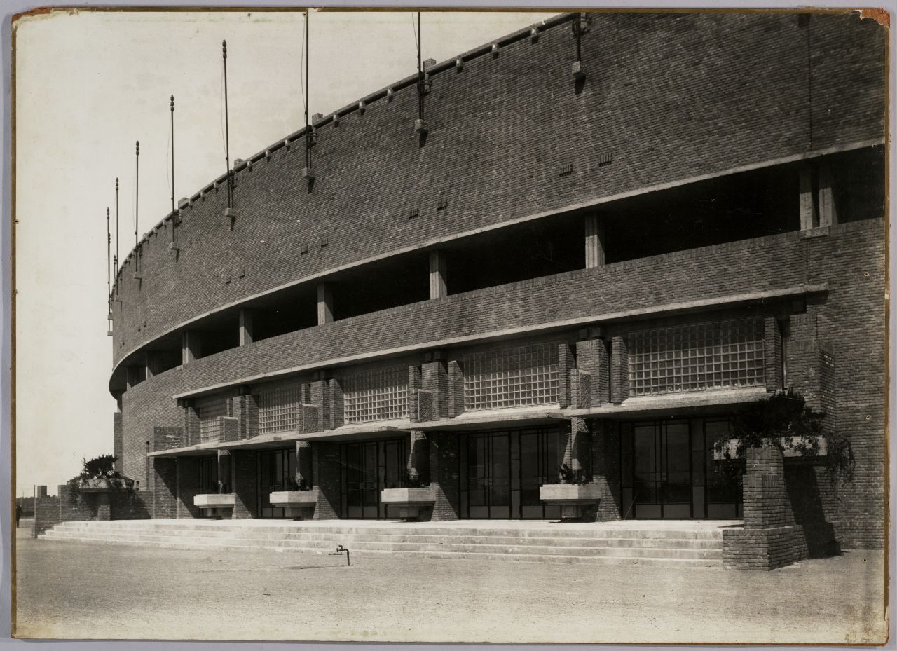 woman in blue tank top standing beside white wall