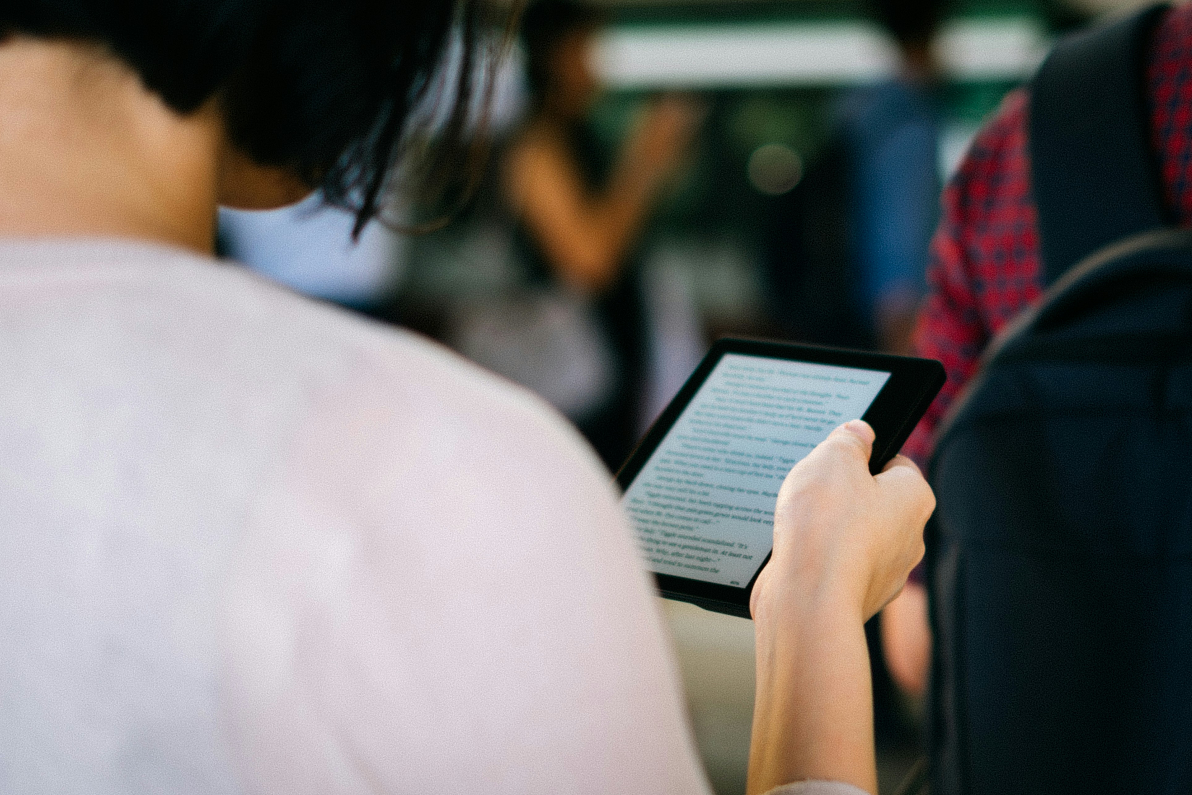 Girl Holding a Kindle Book - How to Turn Kindle Book Into Audiobook