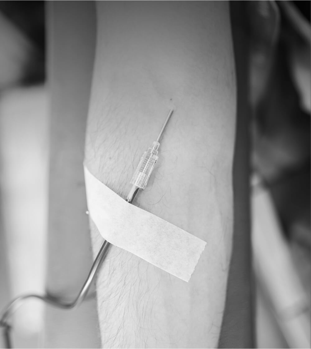 Traditional venipuncture blood draw with needle inserted into arm vein