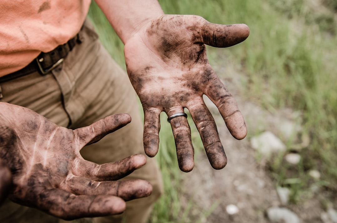 hands of a worker typing on a specialized handheld device with a large digital signature field, focused industrial lighting