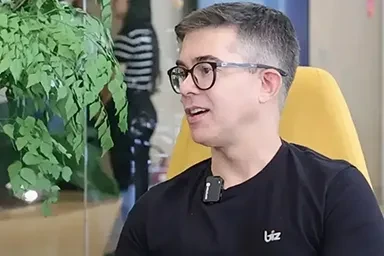 Três pessoas conversam ao ar livre, cercadas por plantas verdes e uma atmosfera relaxante.