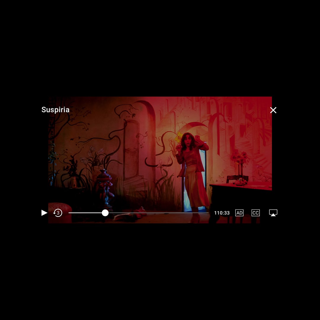 In-app video player showing a scene from Suspiria with playback controls, progress bar, audio description and closed captions toggles, and a runtime of 110:33.