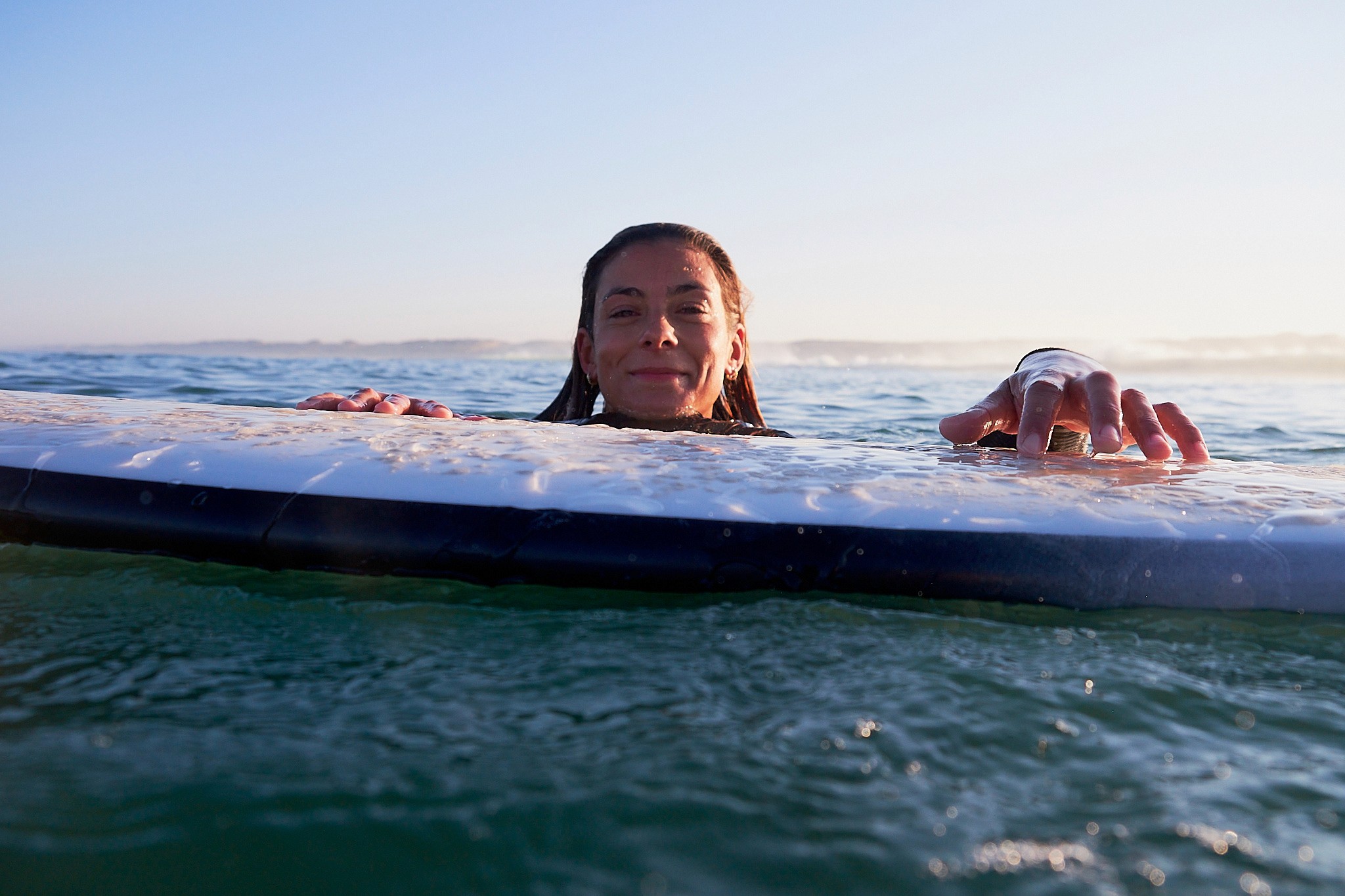 surfer in water holding surfboard