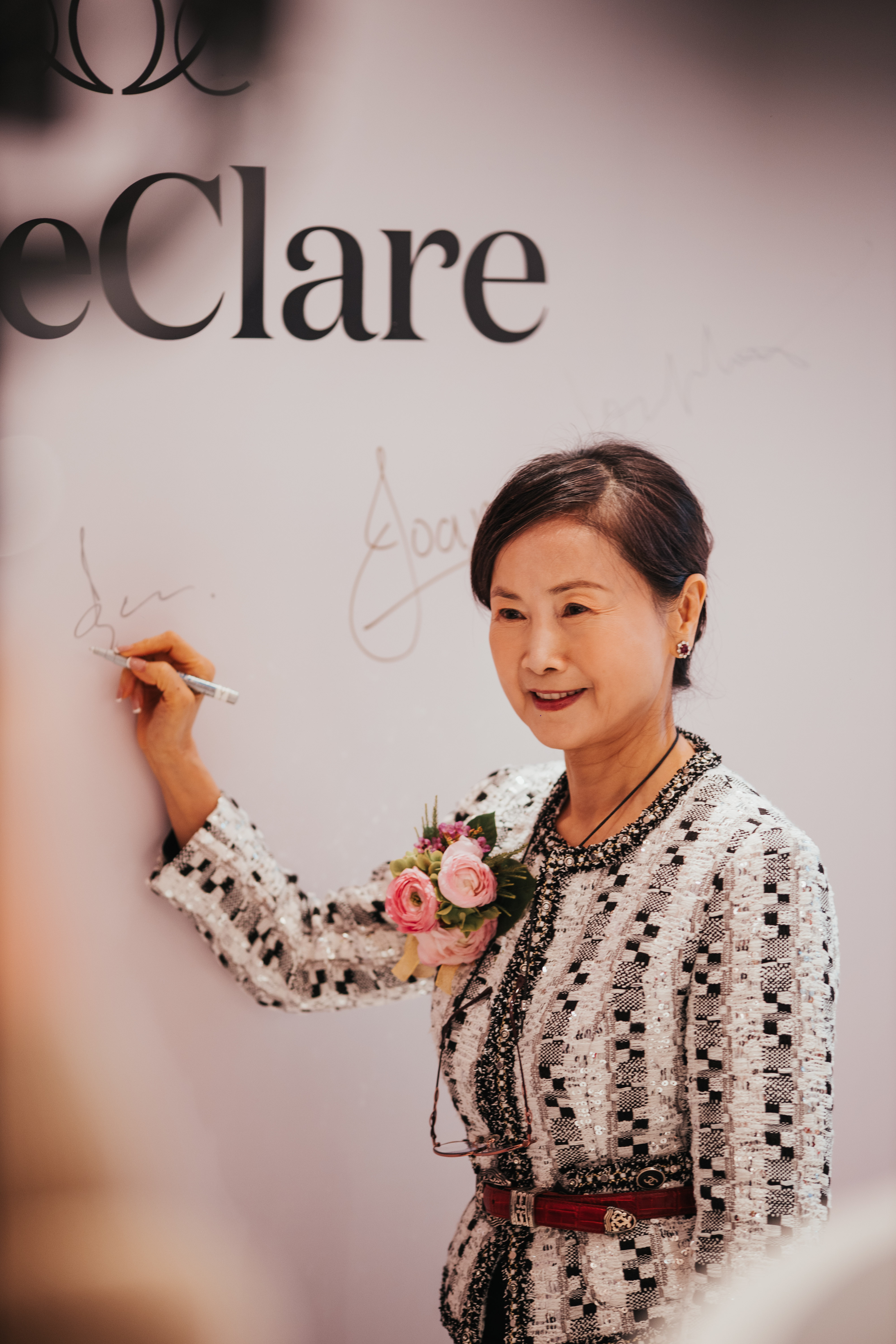 Ms. Lee, the founder of the clean beauty brand JaneClare, is seen signing a wall during the store launch event.