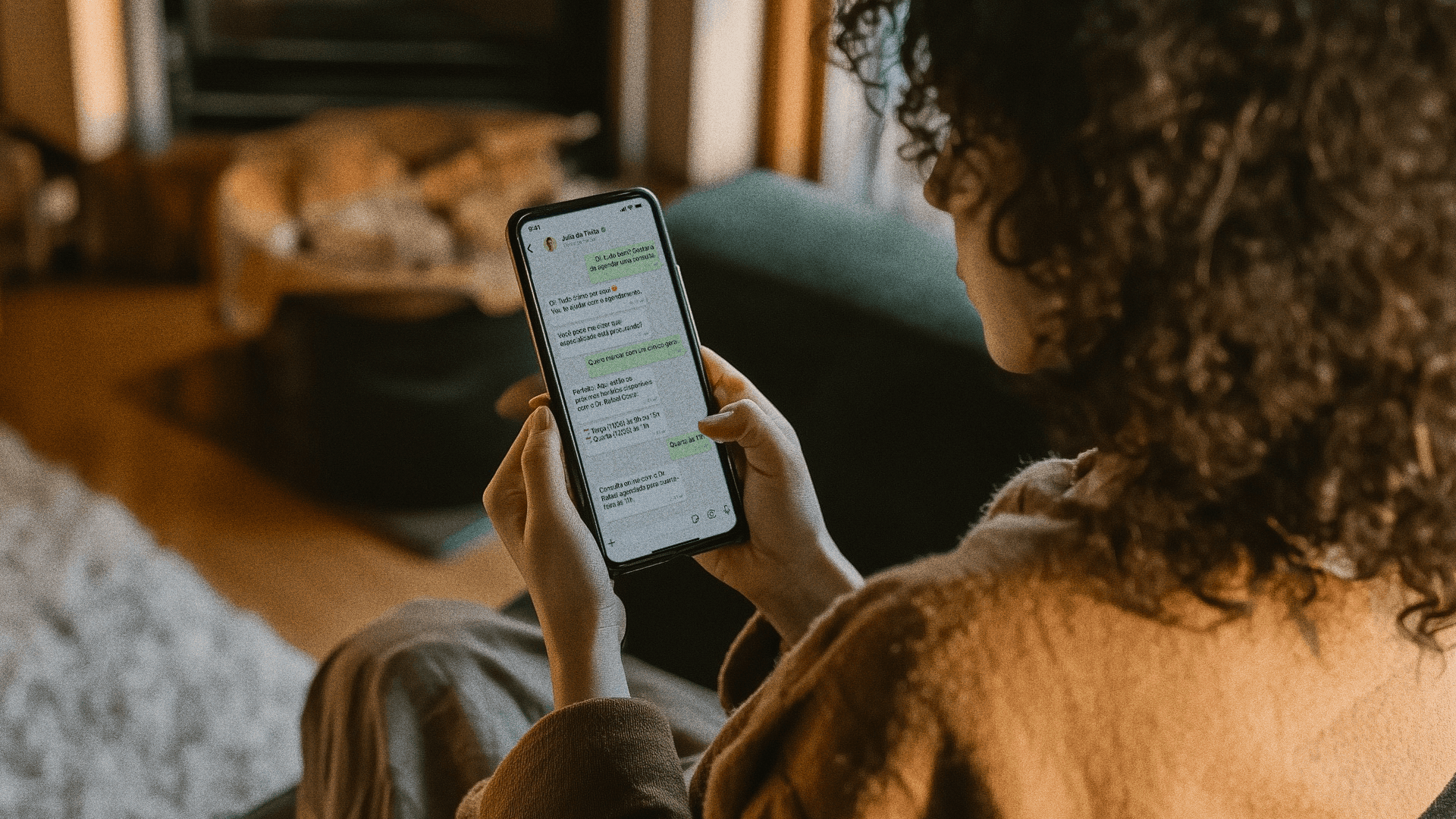 Uma paciente segura seu celular e lê uma mensagem do WhatsApp que detalha o uso de seus dados para um agendamento. A imagem ilustra como a clínica utiliza o WhatsApp em total conformidade com a LGPD, garantindo a privacidade e o consentimento explícito do paciente para o tratamento de suas informações de saúde.