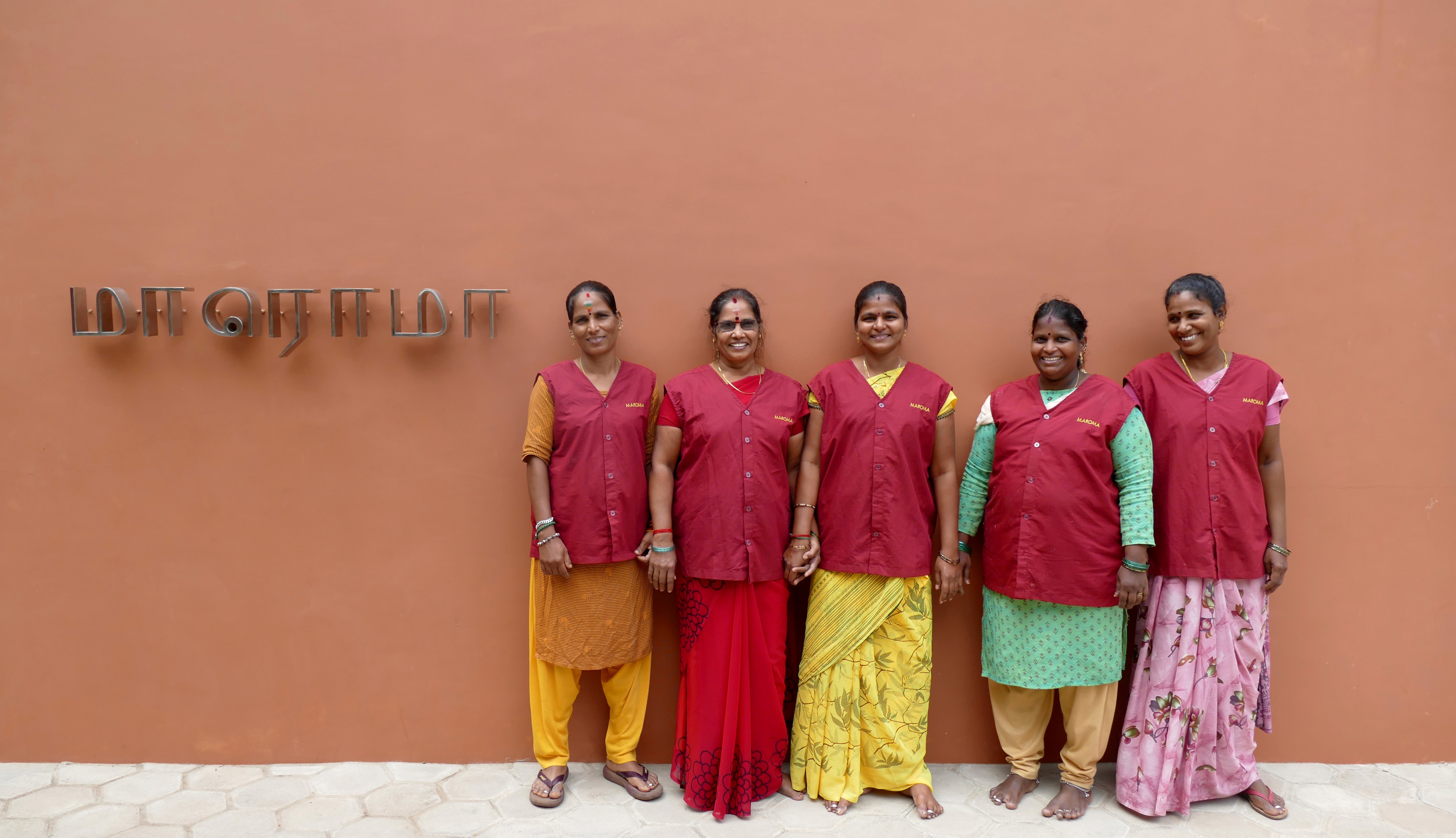 A woman lying down on a soft surface with her eyes closed, bathed in warm sunlight filtering through leaves. Her face has a natural glow, reflecting relaxation and tranquility in a serene spa-like setting.