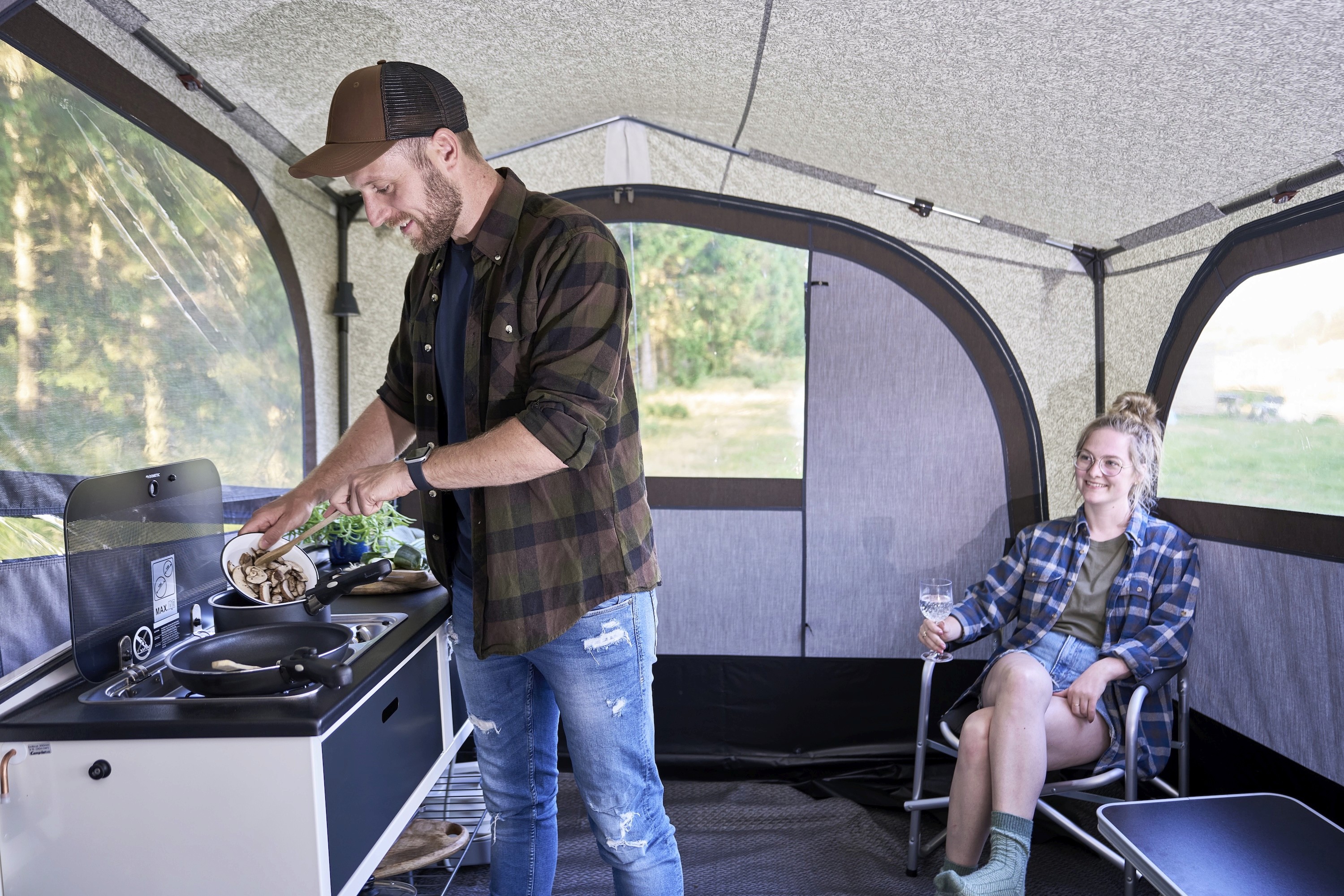 A couple preparing food in a Camp-let Earth Side Tent