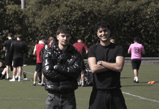 Fundadores de vida universitaria sonriendo en un campo de futbol