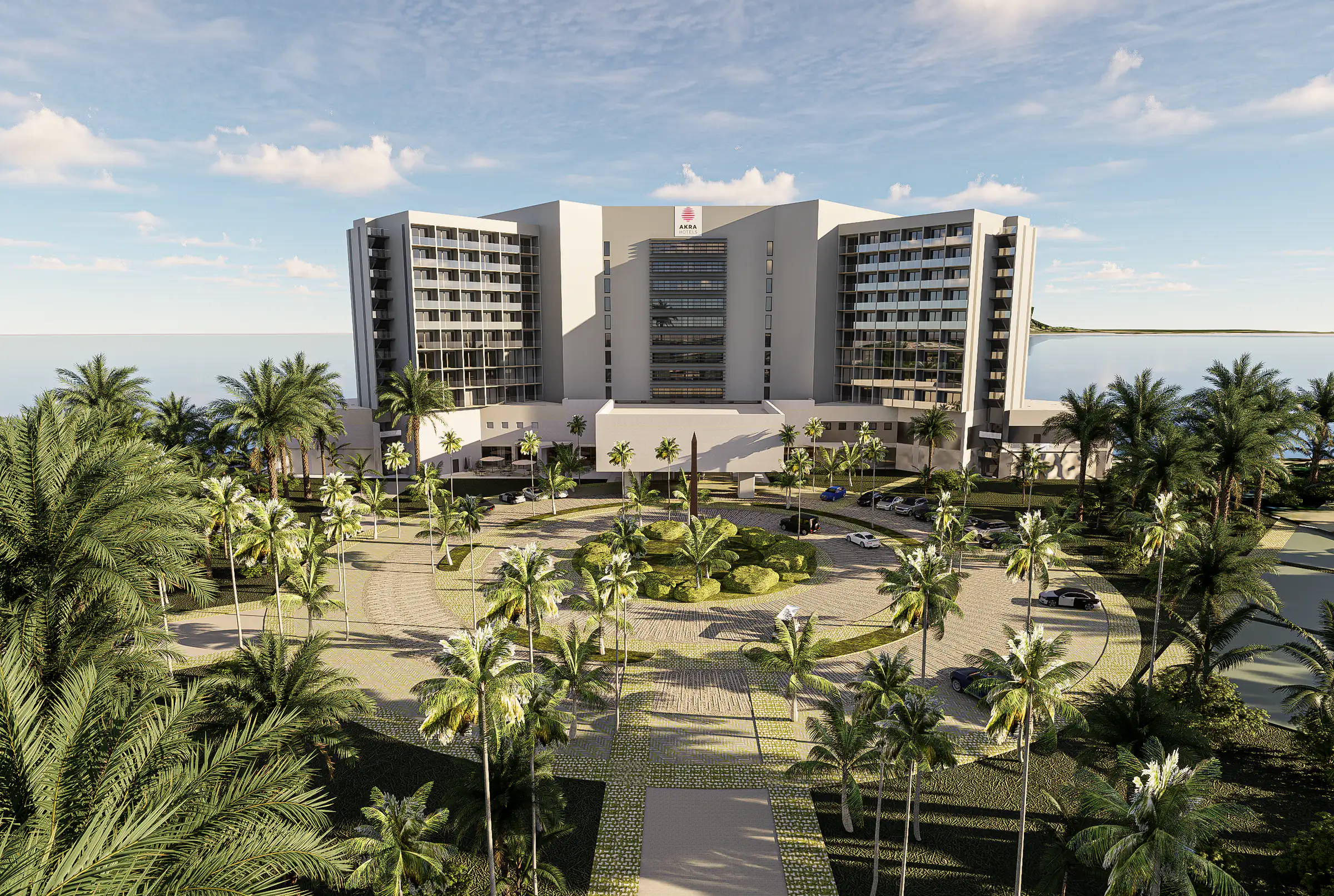 Otel yapısının palmiyeli giriş bahçesiyle birlikte havadan görünümü; arkada deniz