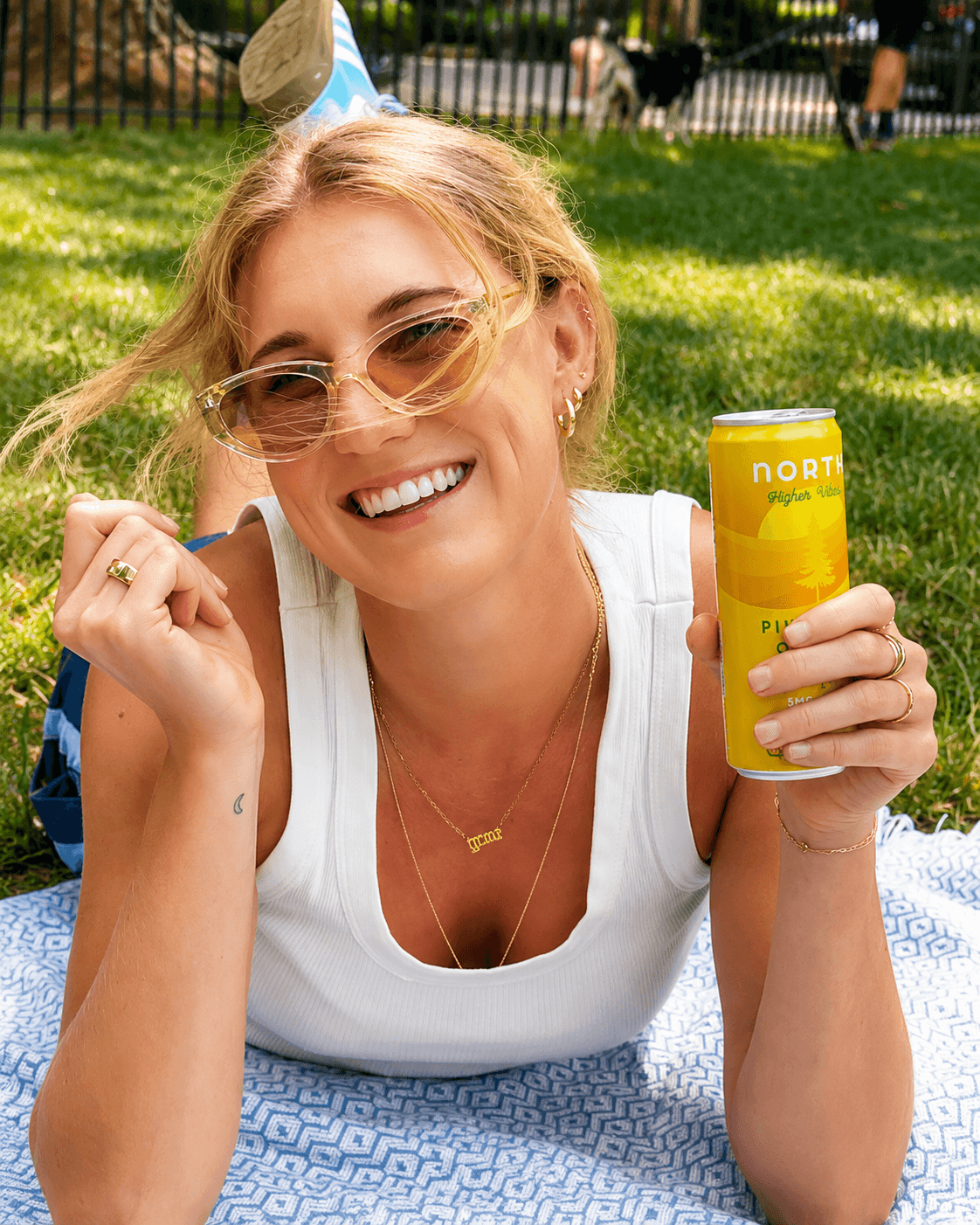 Smiling person holding a North Canna can outdoors