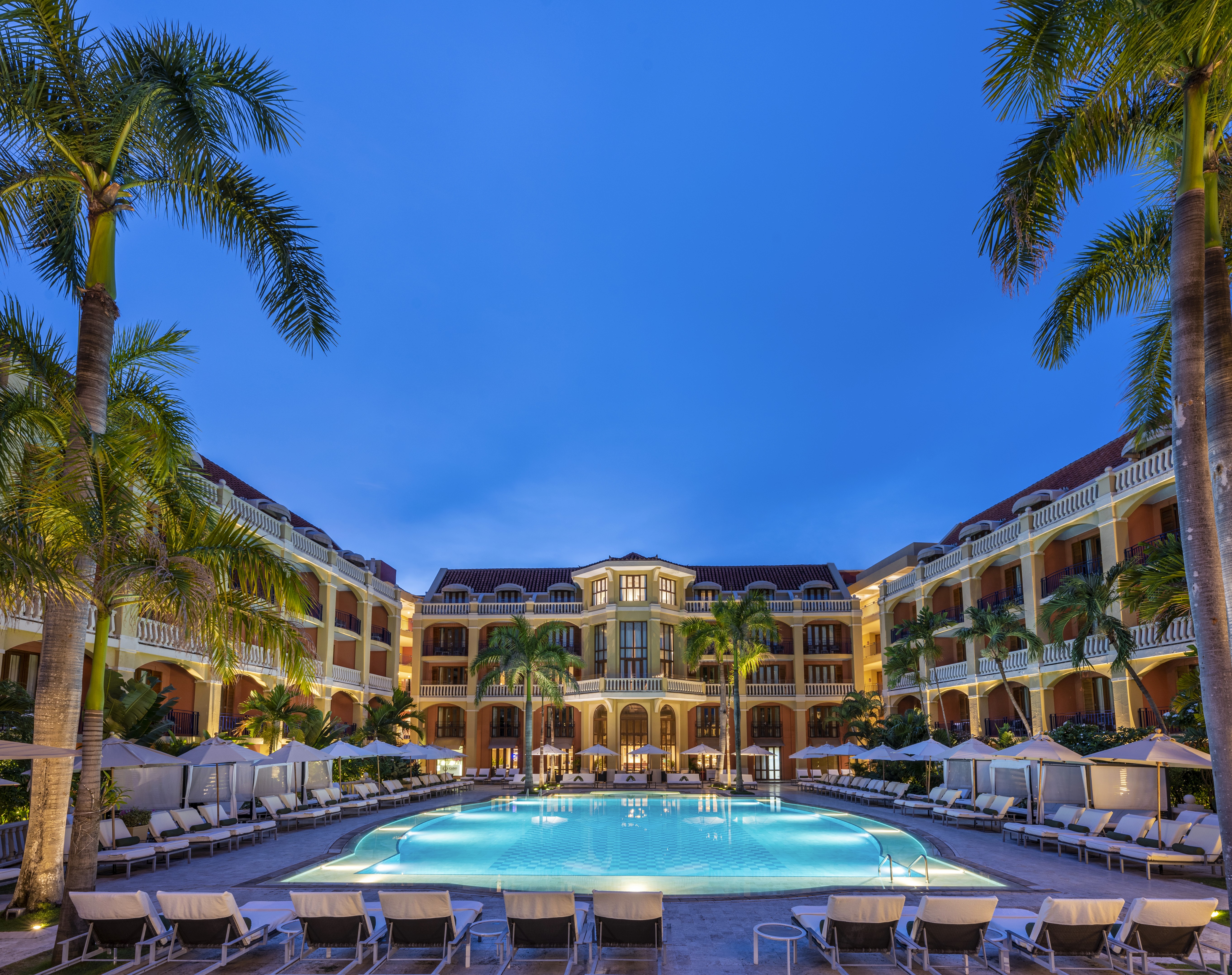 Bold editorial fashion portrait of model in houndstooth blazer with red tie and green shirt against bright turquoise background - Serif Creative Studio luxury fashion photography