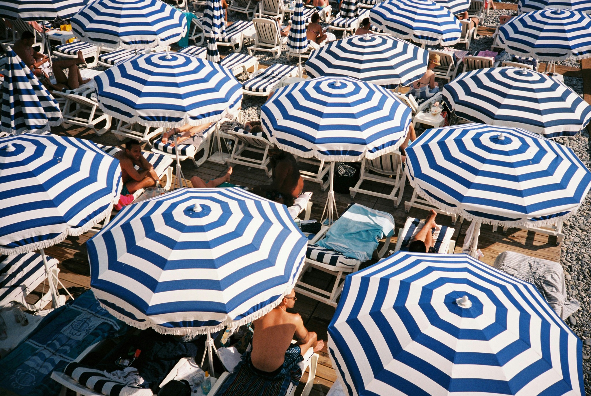Alignement de parasols vintage bleu et blanc : direction artistique épurée pour un site vitrine de tourisme balnéaire.
