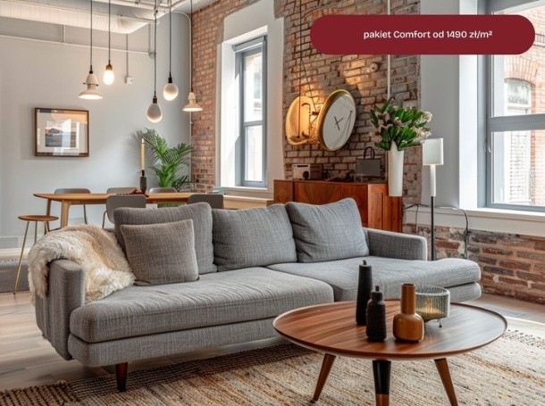 Salon z szarą sofą, okrągłym stolikiem, ceglaną ścianą i dużymi oknami