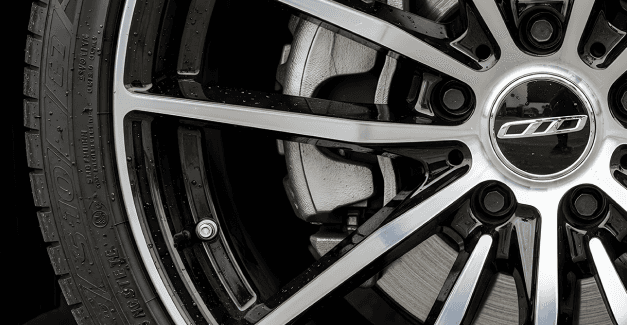 Close up zoomed in photo of a car wheel with shiny spoked design