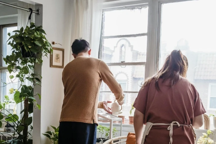 Family watering plants in modern style apartment