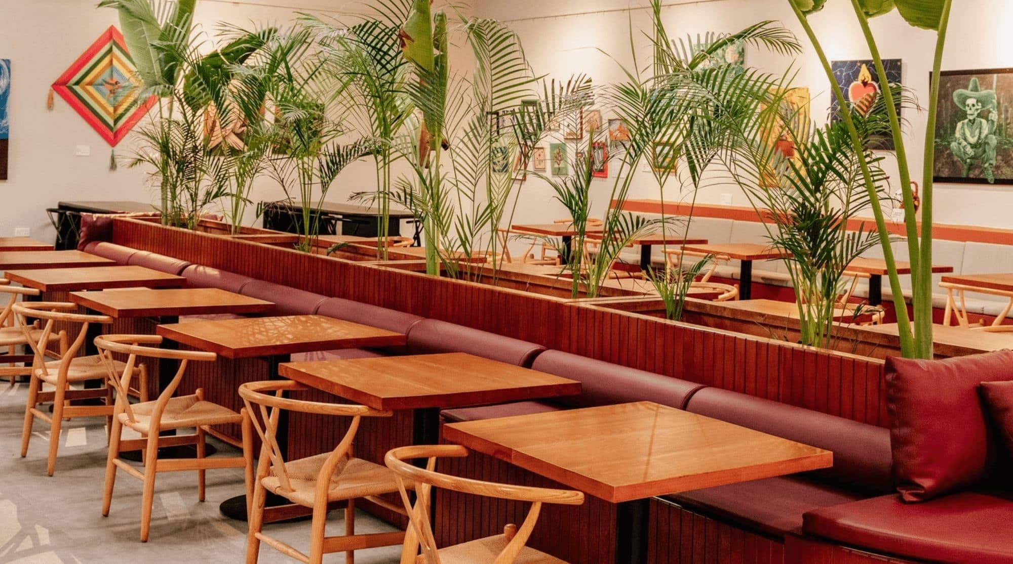 LILA Molina + Cafe in Dubai with red cushioned seats, wooden armchairs, and bright decorations.