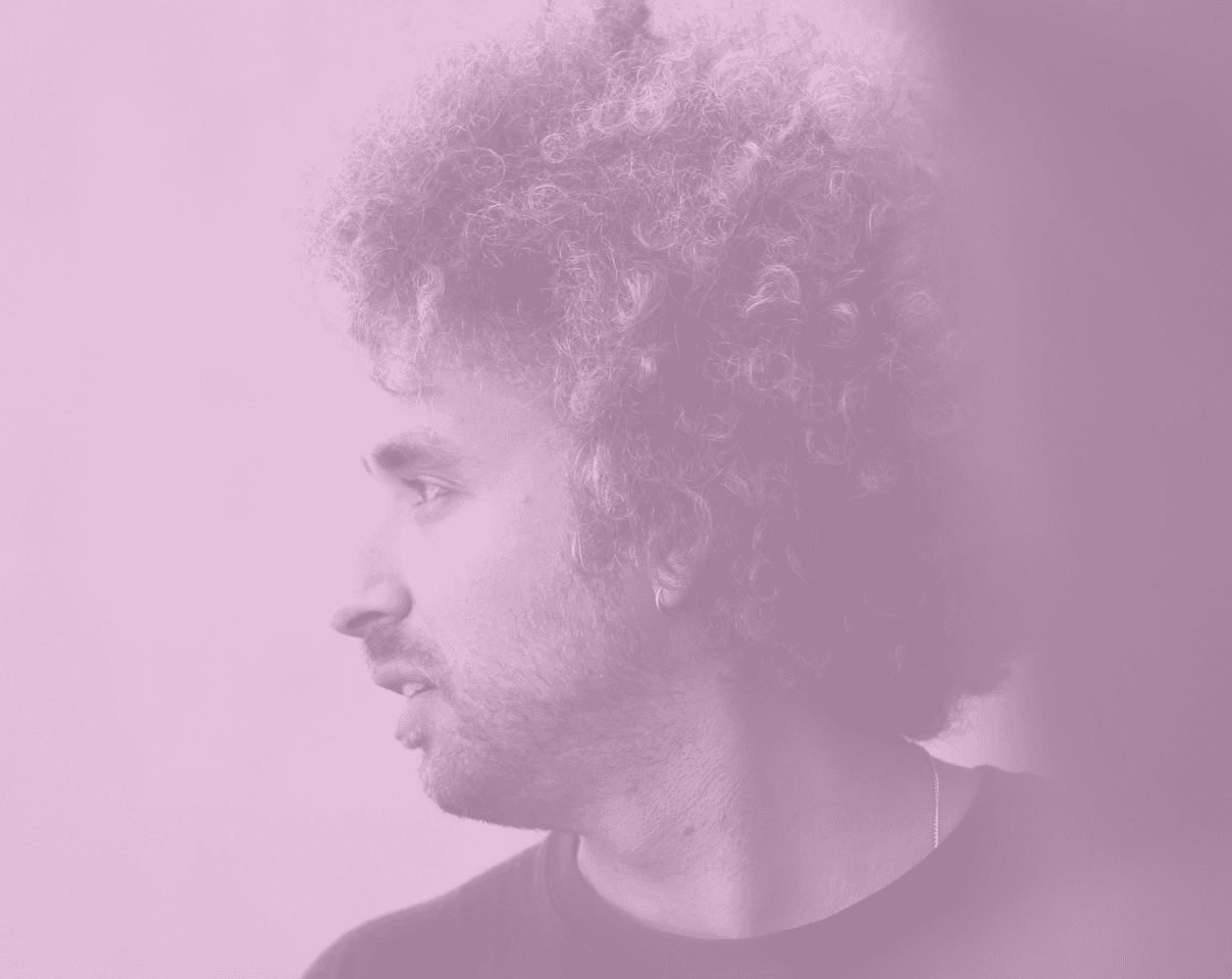 A close-up of a hand wearing multiple decorative rings against a blue background.