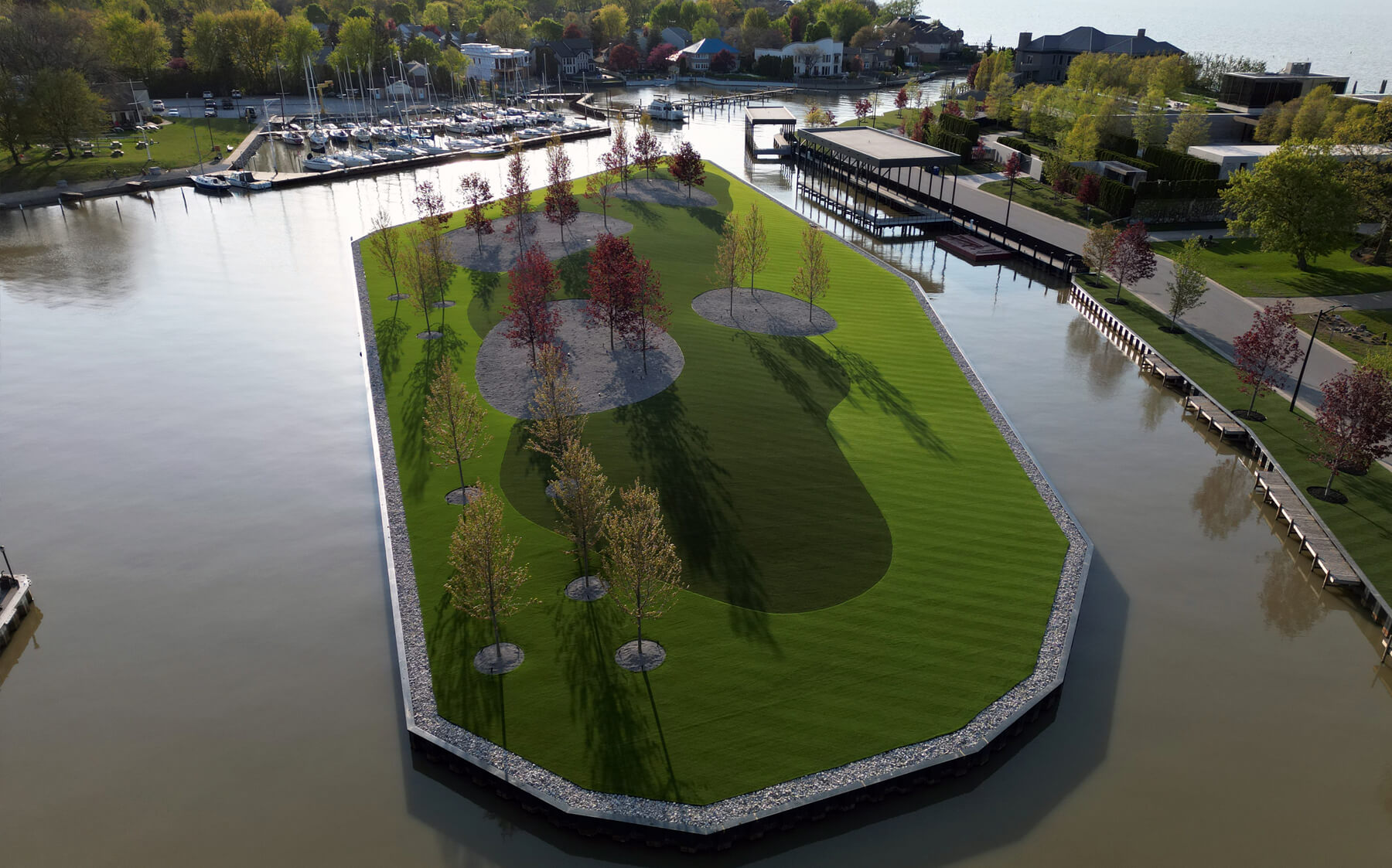 A tranquil floating park with vibrant AGL Grass and trees, beautifully situated on the water.