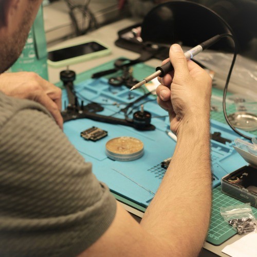 Close-up of hands soldering small electronic components