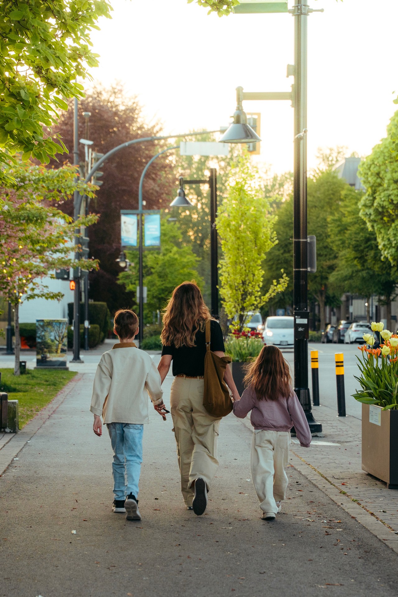 Close-up of a sprinter's hands on a red track surface, holding a black relay baton while positioned at the starting blocks.
